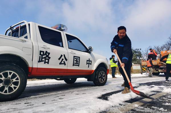 图2：白雪皑皑中最美的“交通蓝”，九支队执法人铲除路面积雪（岑继贤摄）(1).jpg