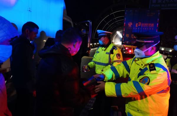 图8：九支队执法人员和交警一起在深夜给受驾乘人员送去食品（李军摄）(1).jpg